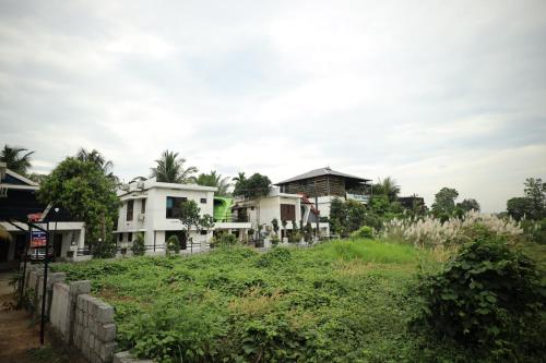 a group of houses on a hill with grass at Ashiyana Homes in Nedumbassery