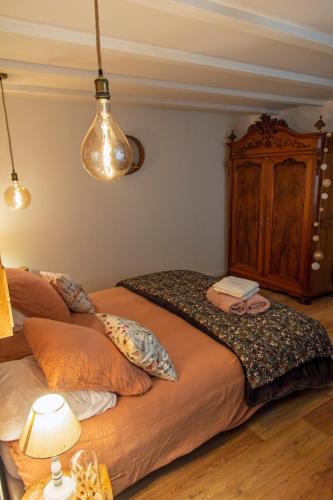 a bedroom with a large bed with a wooden cabinet at chez Thérèse in Auxonne