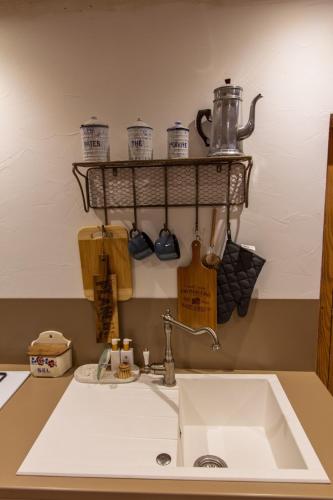 a kitchen counter with a sink and a shelf above it at chez Thérèse in Auxonne