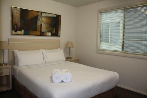 a bedroom with a bed with two towels on it at Ingenia Holidays Nepean River in Emu Plains