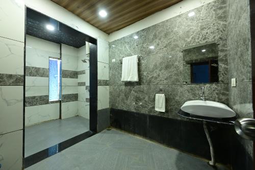 a bathroom with a sink and a shower at Rudrakshi Inn in Mount Ābu