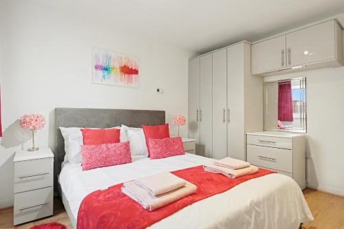 a bedroom with a large bed with pink pillows at Central London flat 10 min to Westminster in London