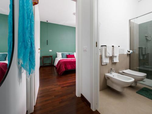 a bathroom with a toilet and a sink and a bed at La Perla Rara in Sant'Agnello