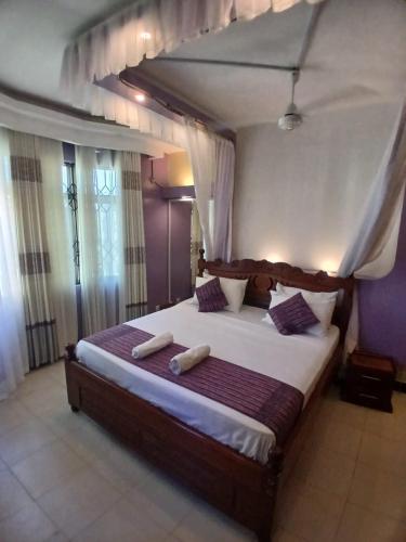 a bedroom with a large bed with two towels on it at Kariba 8 in Mombasa