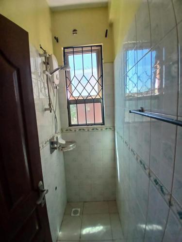 a bathroom with a shower with a window at Kariba 8 in Mombasa