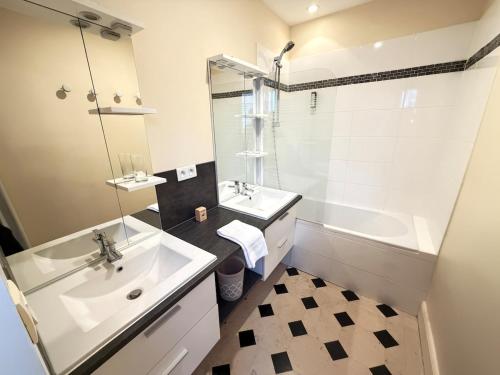 a bathroom with a sink and a tub and a mirror at Studio au cœur du château in Monchy-Humières