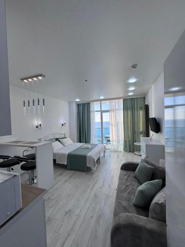 a bedroom with a bed and a living room with a couch at Batumi in the waves in Batumi
