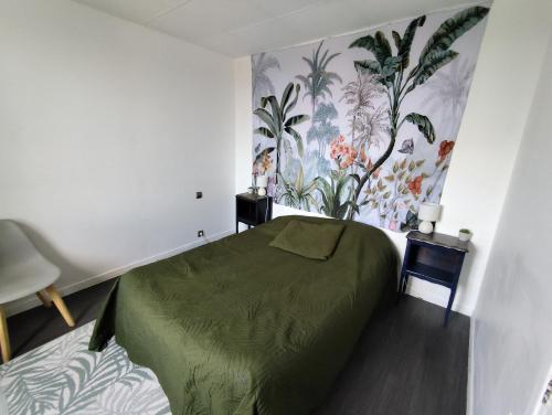 a bedroom with a green bed and floral wallpaper at Maison idéale pour visiter Bordeaux in Ambarès-et-Lagrave