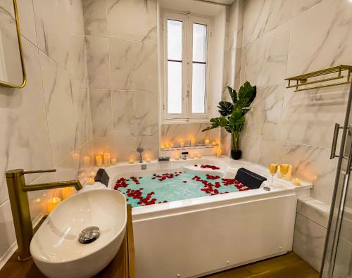 a bathroom with a bath tub filled with red flowers at Glamour & jacuzzi privé Chambéry in Chambéry
