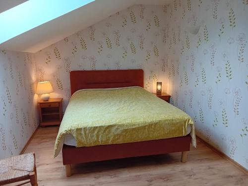 a bedroom with a bed and two end tables at Ferme du Pigeonnier in Montceau-et-Écharnant