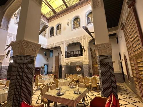 a restaurant with tables and chairs in a building at Riad Fes Bab Rcif Suite &Spa in Fez