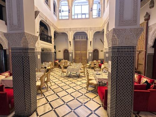 a restaurant with tables and chairs in a building at Riad Fes Bab Rcif Suite &Spa in Fez