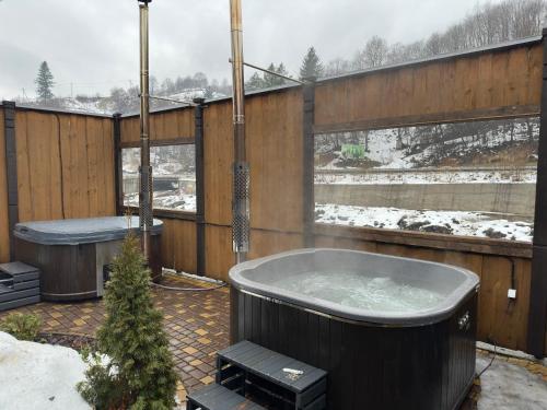 a hot tub on a patio in the snow at Екосадиба Водограй in Kvasy