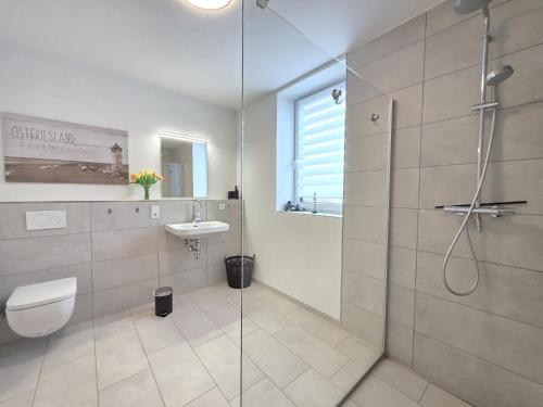a bathroom with a shower and a toilet and a sink at Ferienwohnung NorderHafen in Norden