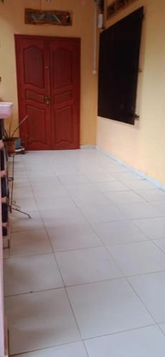 a room with a red door and a television at Maison calme près de la mer in Mutsamudu