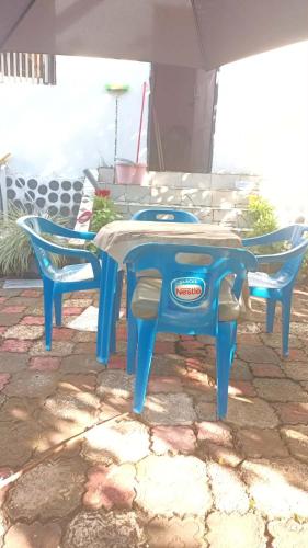 a blue table and two chairs under an umbrella at Maison calme près de la mer in Mutsamudu