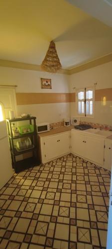 a kitchen with a tiled floor and a counter top at Résidence SUN SHINE DJERBA in Midoun