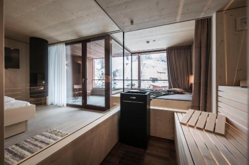 a room with a kitchen with a stove and a bed at Kersh Dolomites Lodge in San Candido
