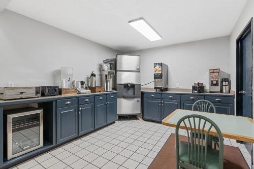 a large kitchen with blue cabinets and appliances at Willow Inn Suites Moorhead Fargo in Moorhead