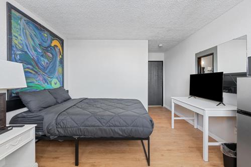 a bedroom with a bed and a desk with a computer at Willow Inn Suites Moorhead Fargo in Moorhead