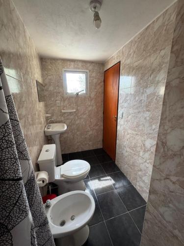 ein Badezimmer mit zwei Toiletten und einem Waschbecken in der Unterkunft El Teyu in Miramar