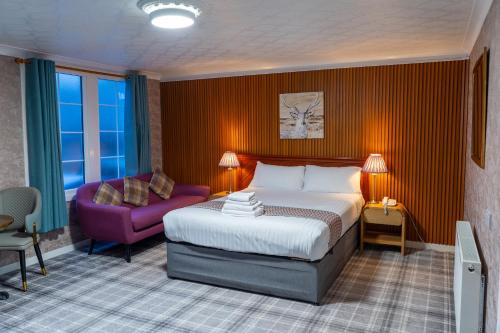 a hotel room with a bed and a purple chair at Grampian Hotel in Perth