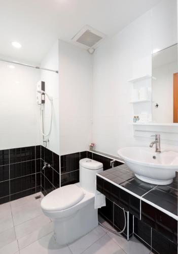 Un baño con un inodoro blanco y un lavabo. en Baan I Inspire, en Phrae