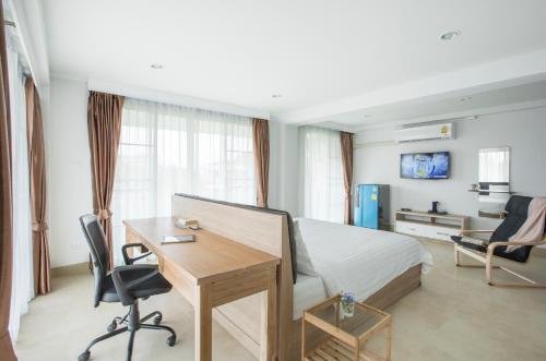 a hotel room with a bed and a desk and a bedroom at Baan I Inspire in Phrae