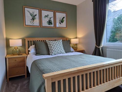 a bedroom with a bed with two lamps and a window at Schooner Point Guest House in Looe