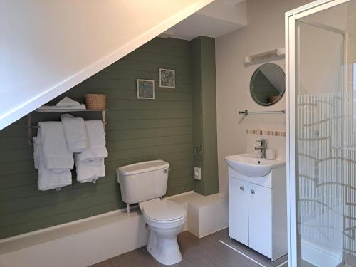 a bathroom with a toilet and a sink at Schooner Point Guest House in Looe