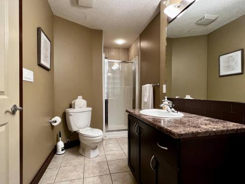 a bathroom with a toilet and a sink and a shower at 2 Bed 2 Bath with Fire Place in Fernie