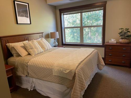 a bedroom with a large bed and a window at 2 Bed 2 Bath with Fire Place in Fernie