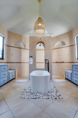 a large bathroom with a tub and two sinks and a mirror at Spacious House with Pool and BBQ in Arenales