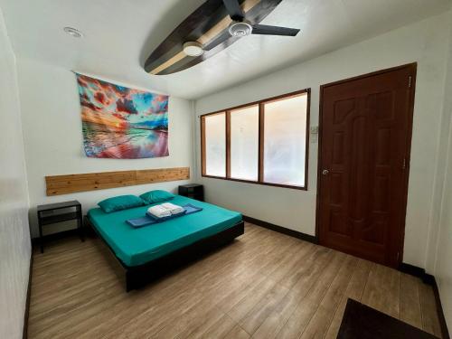 a bedroom with a green bed in a room with a door at North Shore Surf Camp in Baler