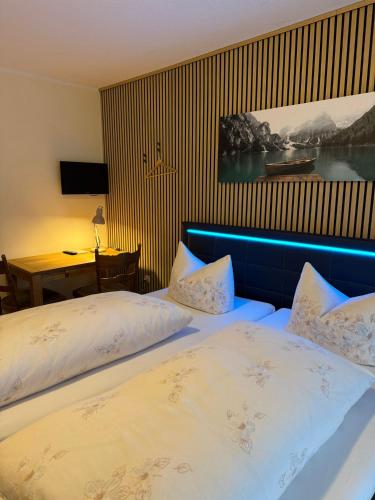 a bedroom with a bed with a blue head board at Gasthaus Decker in Mittenaar
