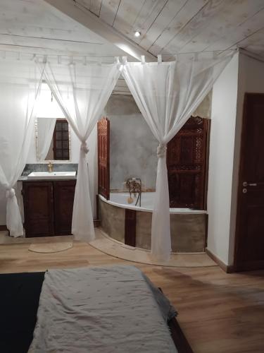 a large bathroom with a tub and a sink at Côté fontaine in Orange