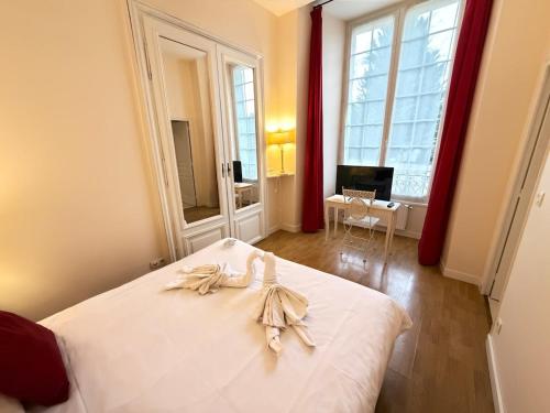 a bedroom with a bed with white sheets and a desk at Studio au château in Monchy-Humières