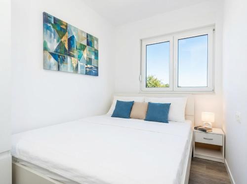 a bedroom with a white bed and two windows at Casa Del Mar in Stara Novalja