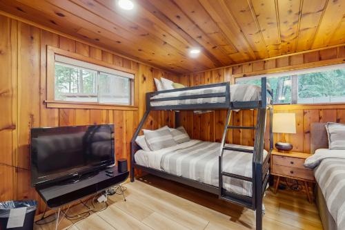 a bedroom with a bunk bed and a flat screen tv at Eagle Beach Retreat in Freeland