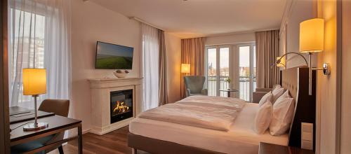 a hotel room with a bed and a fireplace at Hotel am Delft in Emden