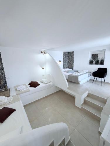 a white room with two beds and a staircase at Villa Livadaros in Karterados