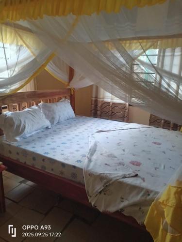 a bedroom with a bed with a mosquito net at Kizi Villas in Watamu