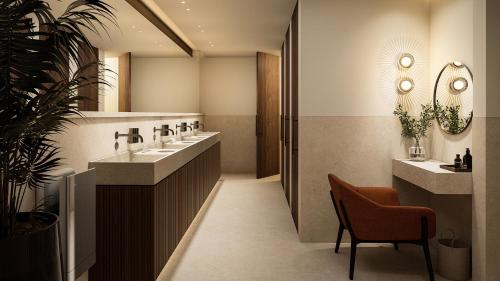 a bathroom with two sinks and a chair at Senator Banus Adults Only Recommended in Estepona