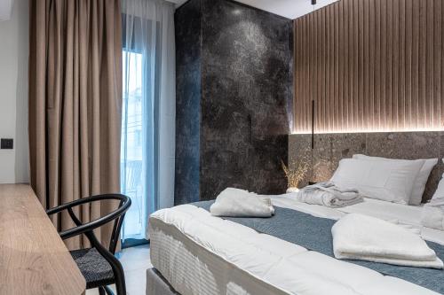 a bedroom with two beds and a table and a chair at Opulence12 Suites in Karpathos