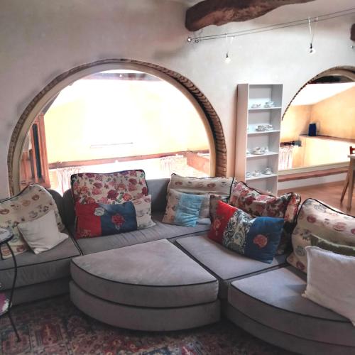 a living room with a couch and pillows at Chambres d'Hôtes Le Loubet in LʼIsle-Jourdain