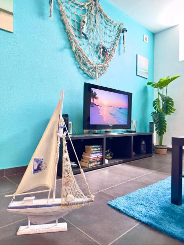 a living room with a tv and a hammock at O Cantinho do Zé in Funchal
