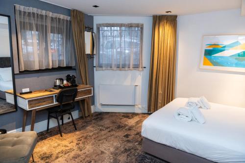 a hotel room with a desk and a bed at S&A Vondel Park Hotel in Amsterdam