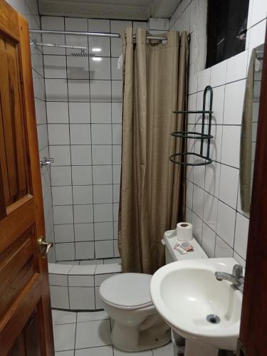 a bathroom with a toilet and a sink and a shower at Hotel Gavilu in Ambato