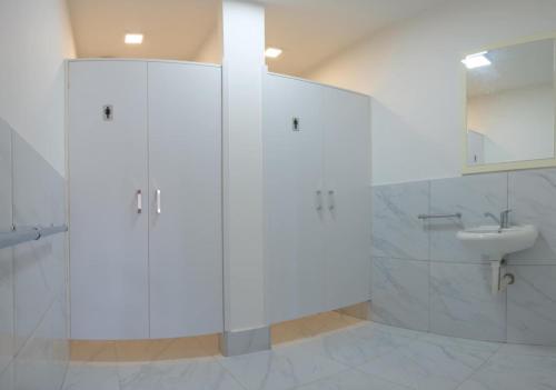 a white bathroom with a sink and a toilet at Garden Hostel in Skopje