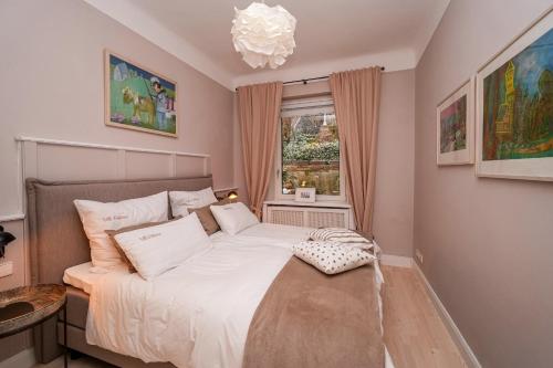 a bedroom with a bed with a chandelier and a window at Villa Botanica in Neustadt an der Weinstraße